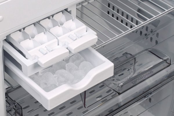 Essential components for a freezer ice maker laid out on a kitchen counter.