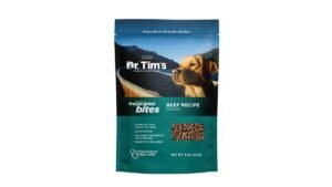 A bag of dog food sits beside a filled metal bowl.