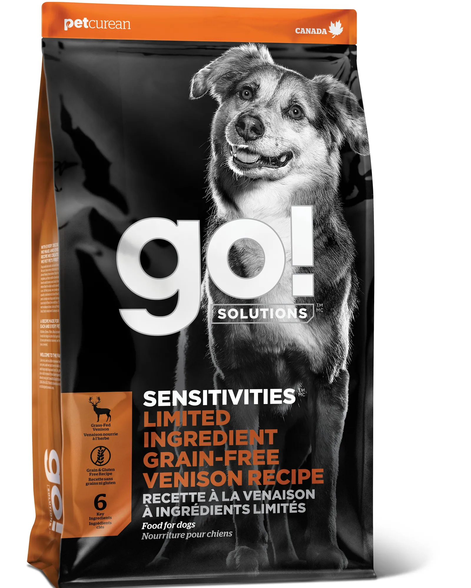 An energetic puppy sitting next to high-quality growth-specific dog food.
