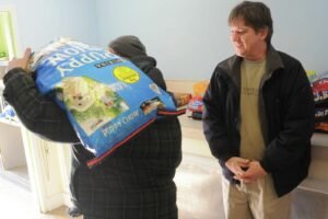 A large bag of dog food beside an airtight storage container.