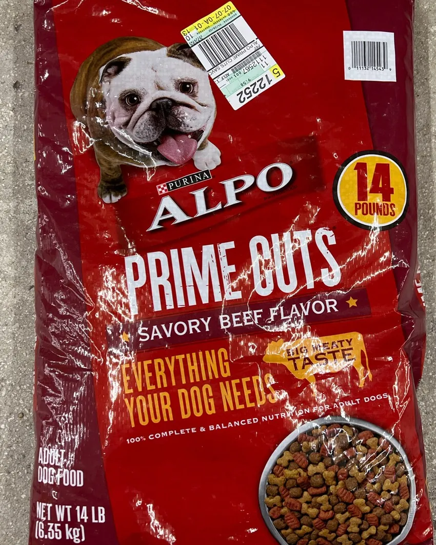 Person safely lifting a heavy bag of dog food into a car.